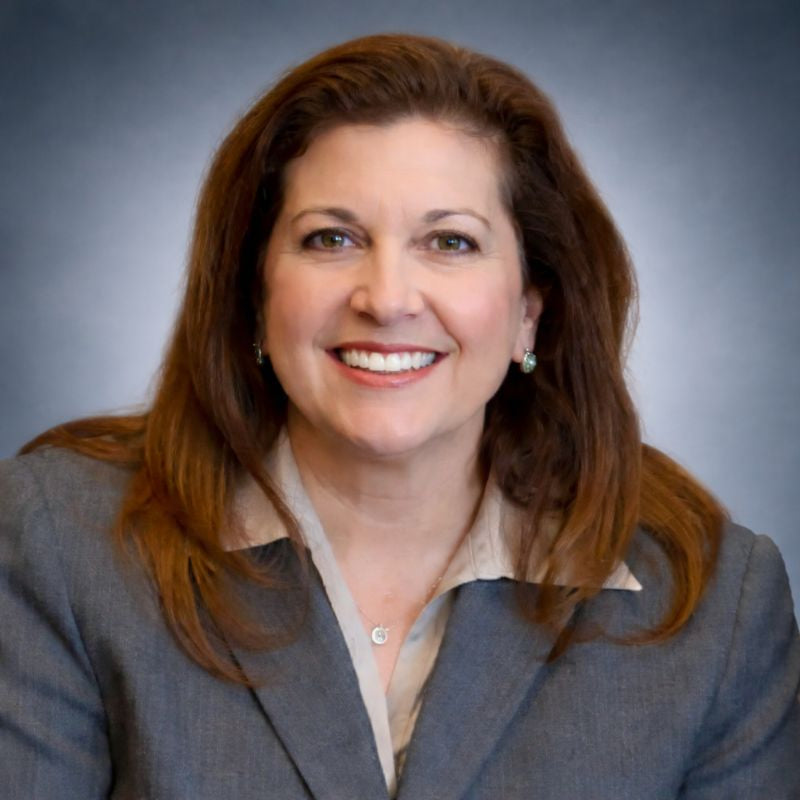 Woman in a gray blazer against a gray background