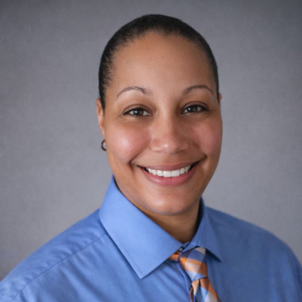 Person wearing a blue shirt and plaid tie against a gray background