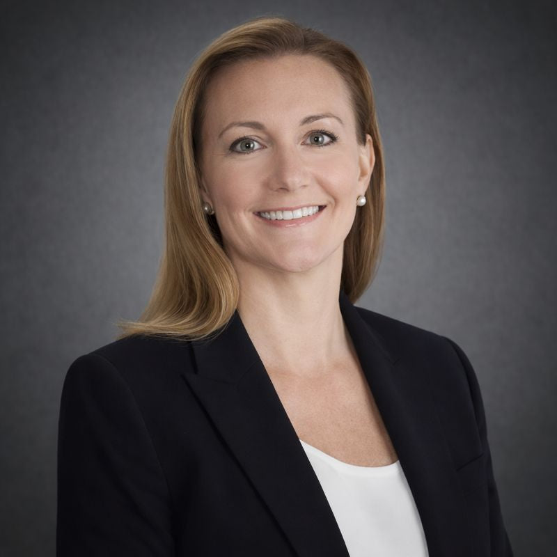 Woman wearing a black blazer against a gray background